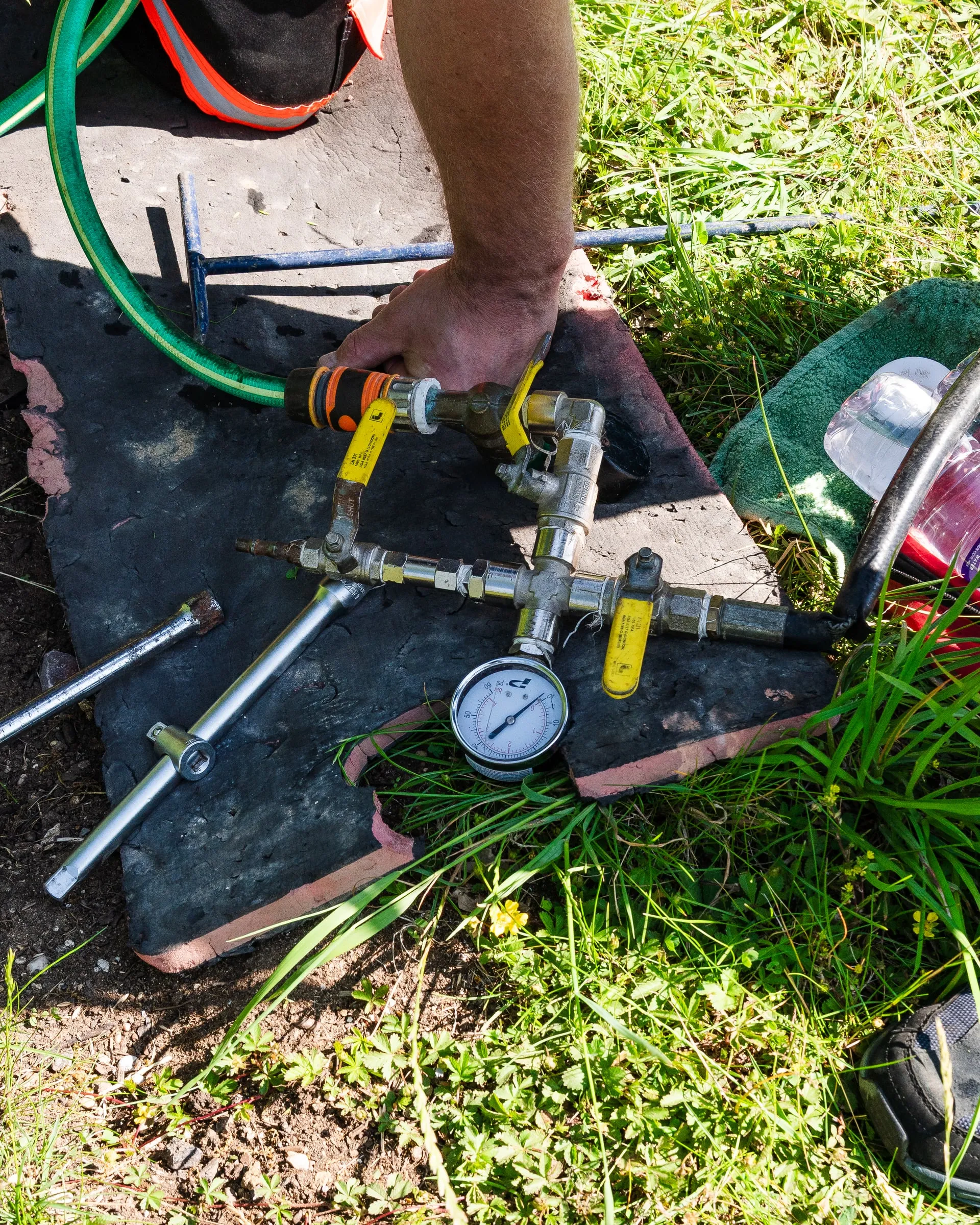 Pressure test rig with a gauge connected to a pipe, laid out on the ground